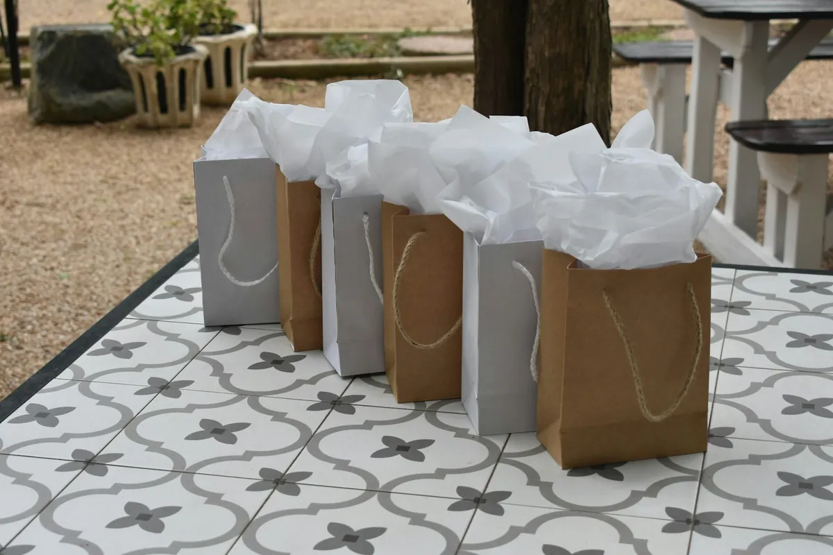 Small kraft paper gift bags on a tiled outdoor table