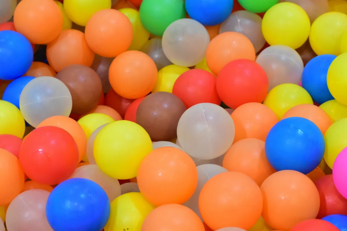 Orange, blue and white play balls in a pit
