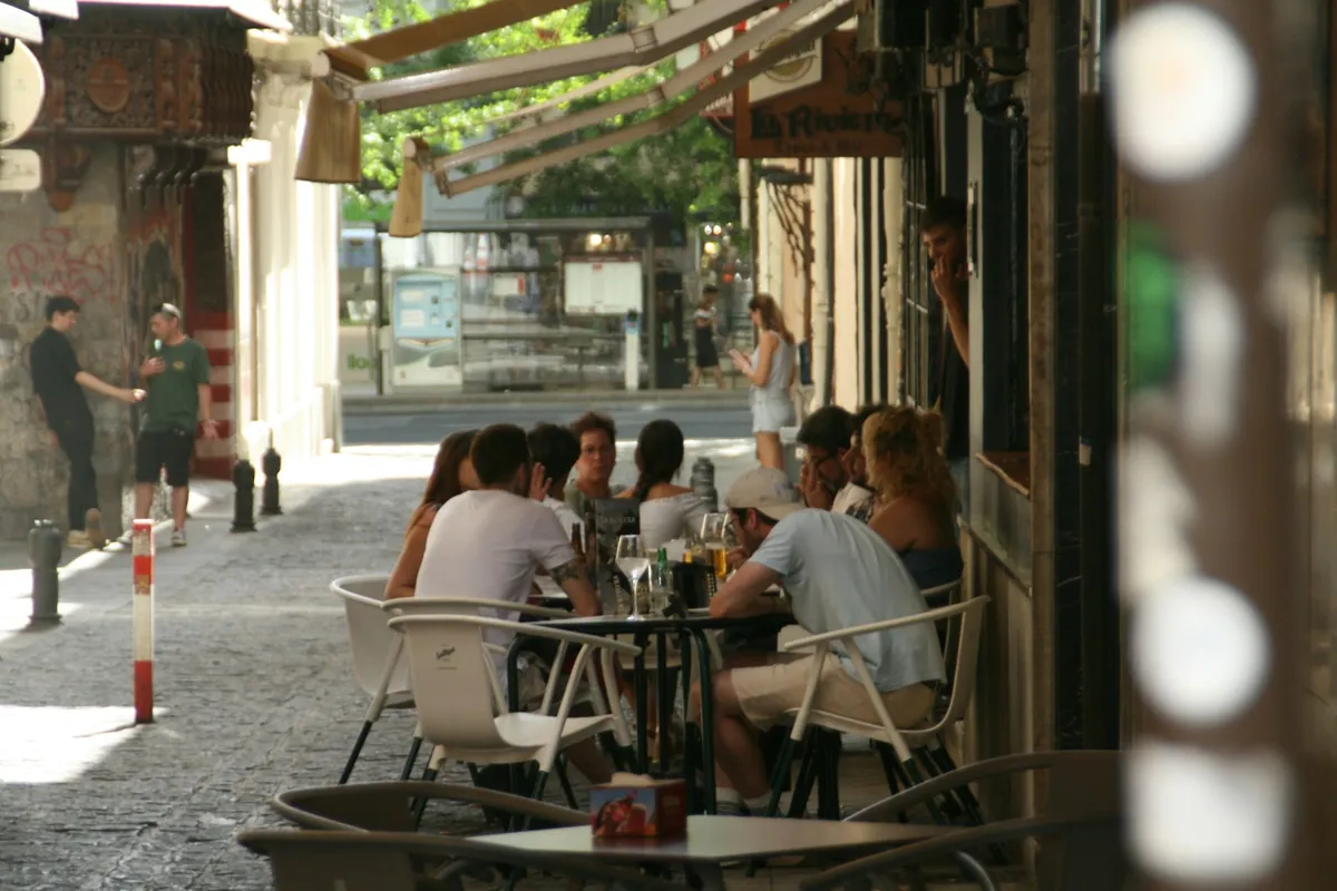 Outdoor cafe tables and chairs on a shaded street