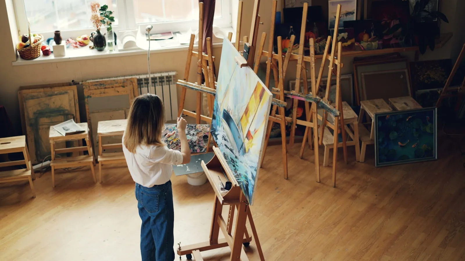Easels set up with blank canvases in a bright studio