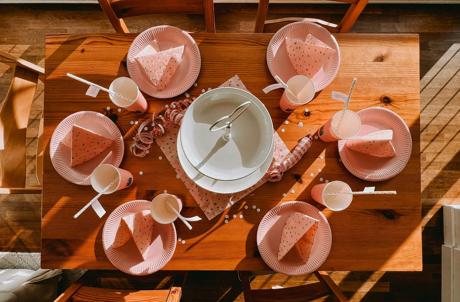 An overhead view of a table laid with blush plates and cups