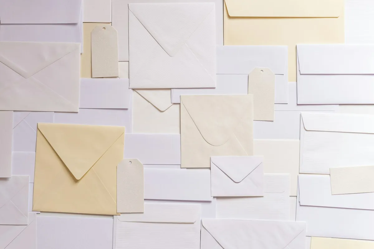 Pastel coloured envelopes scattered across a pale surface