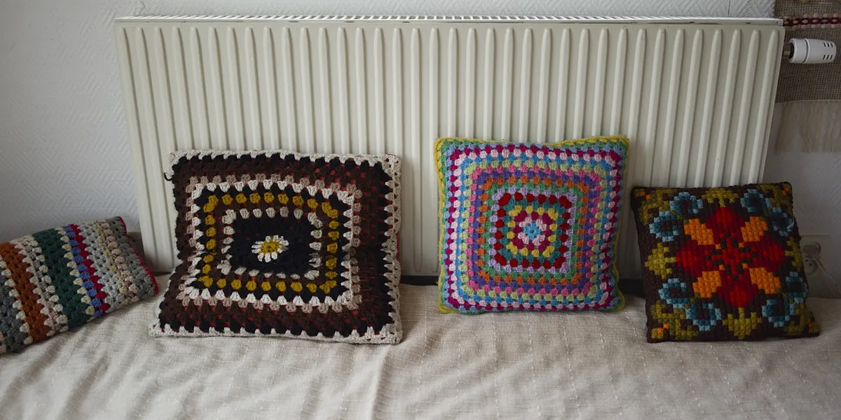 Patterned crocheted cushions arranged on a bed