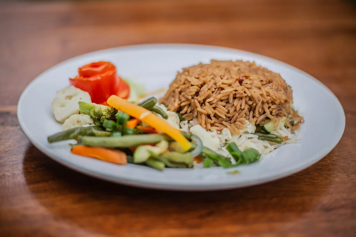 A plate of rice with steamed carrots and green beans
