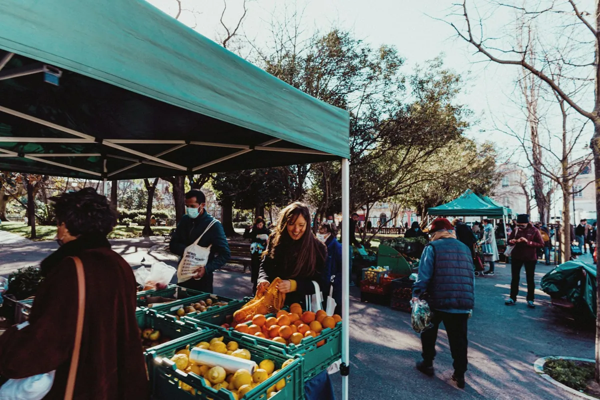 Shoppers browsing stalls at an outdoor farmers market
