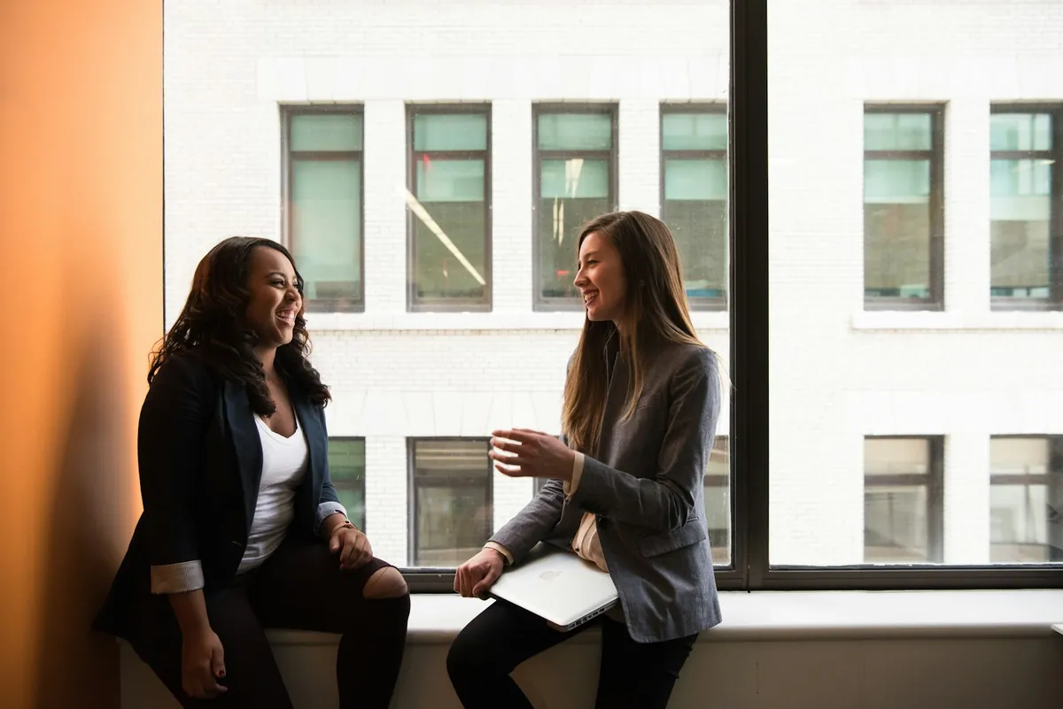 Two people standing and talking outside a building