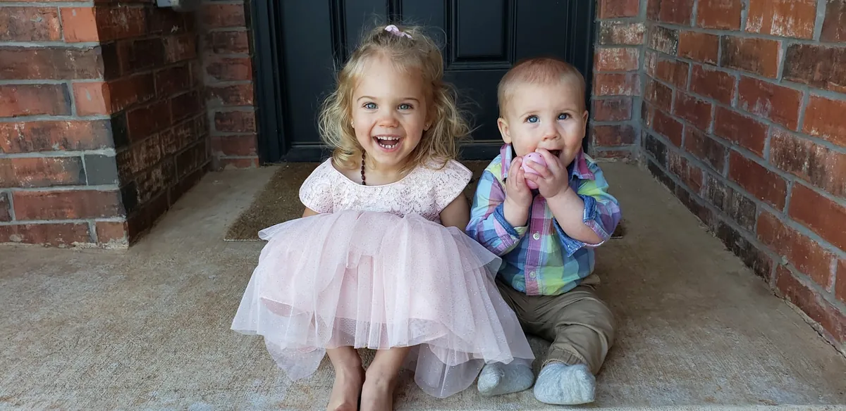 Two toddlers standing together outdoors