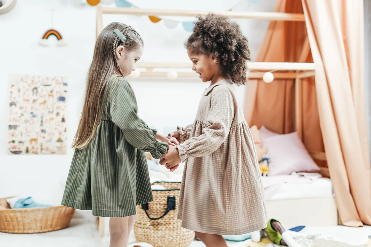 Two young children playing together in a softly lit playroom